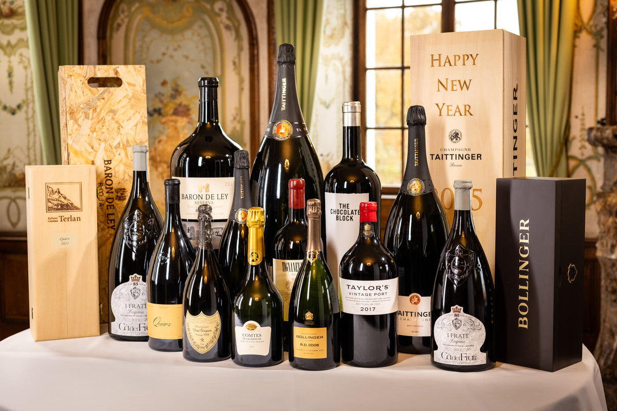 Originalaufnahme: große Wein- und Champagnerflaschen mit Beispielen persönlich gravierter Holzkisten